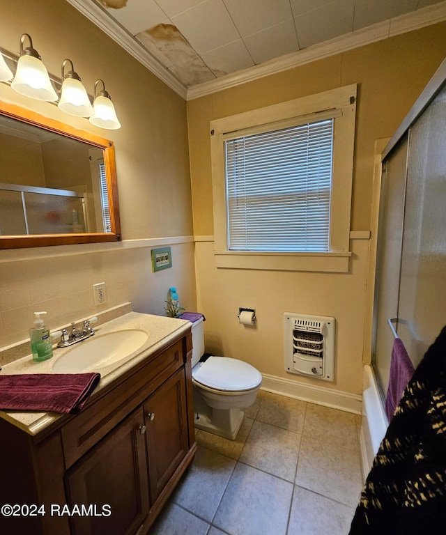 full bathroom with heating unit, shower / bath combination with glass door, ornamental molding, vanity, and toilet