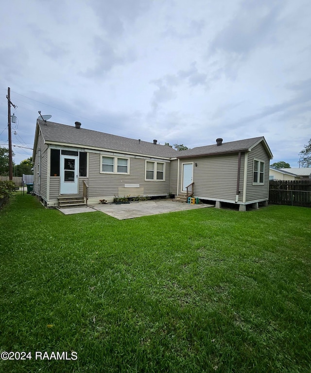 rear view of property featuring a lawn and a patio