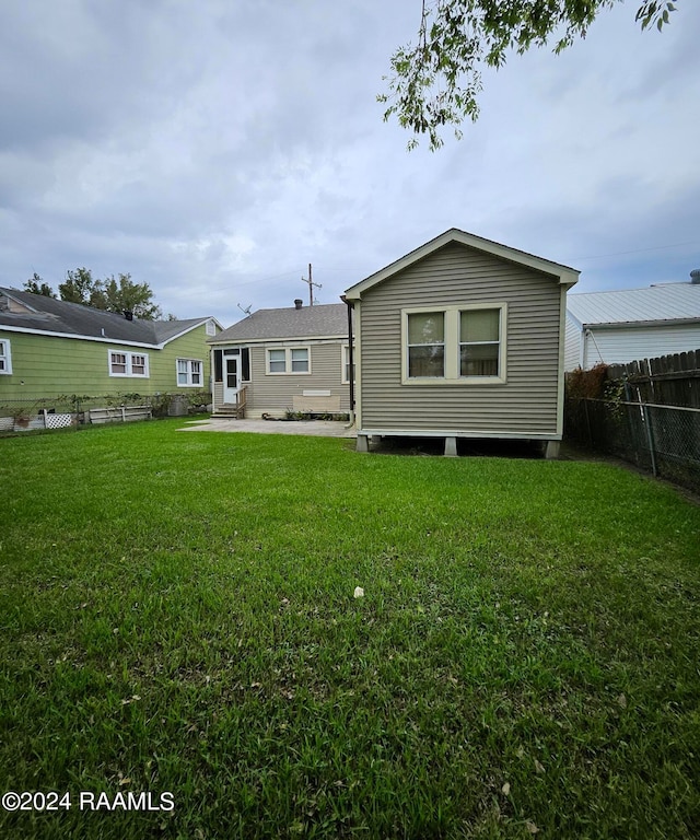 back of property featuring a lawn and a patio