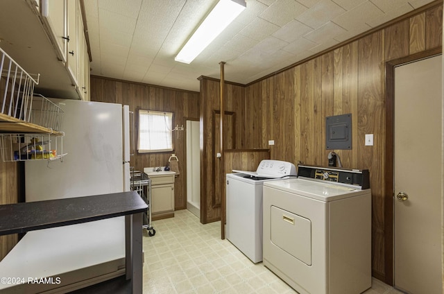 14311 William Rd, Kaplan, LA 70548 - laundry room with light floors, independent washer and dryer, electric panel, wood walls, and cabinet space