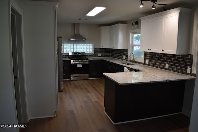 kitchen featuring appliances with stainless steel finishes, sink, wall chimney exhaust hood, white cabinets, and dark hardwood / wood-style floors