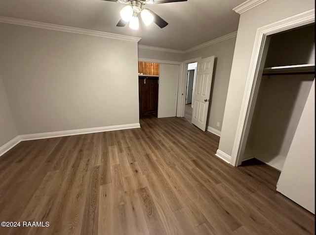 unfurnished bedroom with a closet, crown molding, wood-type flooring, and ceiling fan