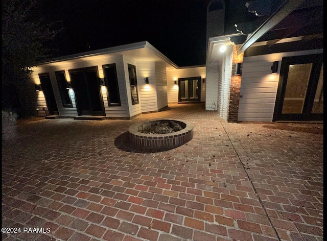 exterior entry at night with a patio