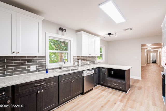 2862 S Union St, Opelousas, LA 70570 - kitchen with a sink, dishwasher, white cabinetry, decorative backsplash, and light wood-type flooring