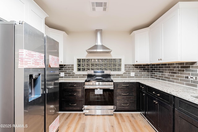 2862 S Union St, Opelousas, LA 70570 - kitchen with appliances with stainless steel finishes, wall chimney range hood, white cabinets, and light wood-style floors