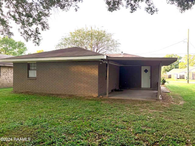 rear view of house featuring a yard and a carport