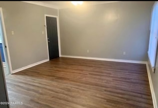 unfurnished room with dark wood-type flooring