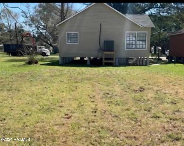 view of side of home with a yard