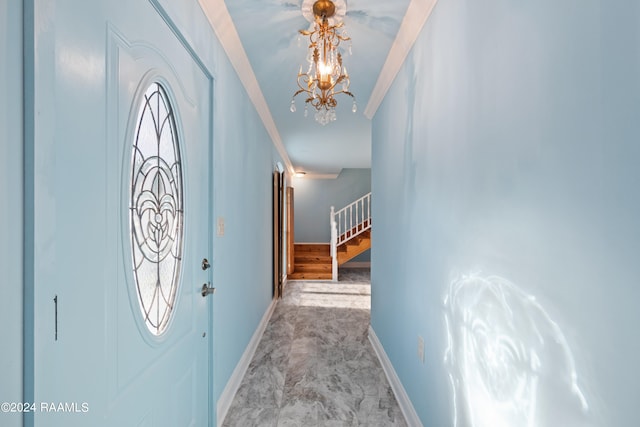 foyer entrance featuring crown molding and a chandelier