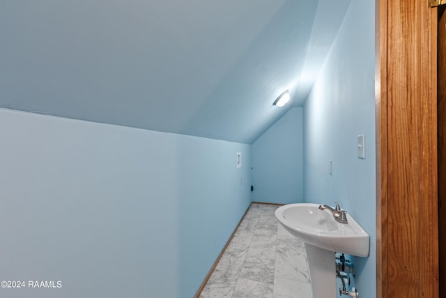 bathroom with lofted ceiling and sink