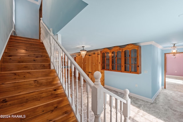 stairs featuring an inviting chandelier and carpet