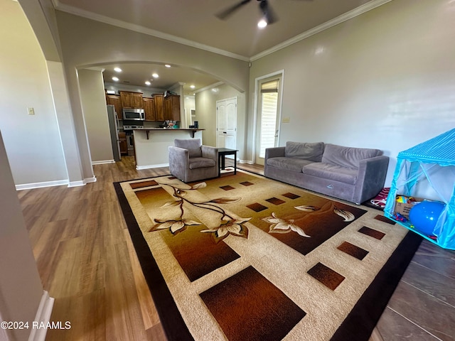 living room with ceiling fan, crown molding, and dark hardwood / wood-style flooring