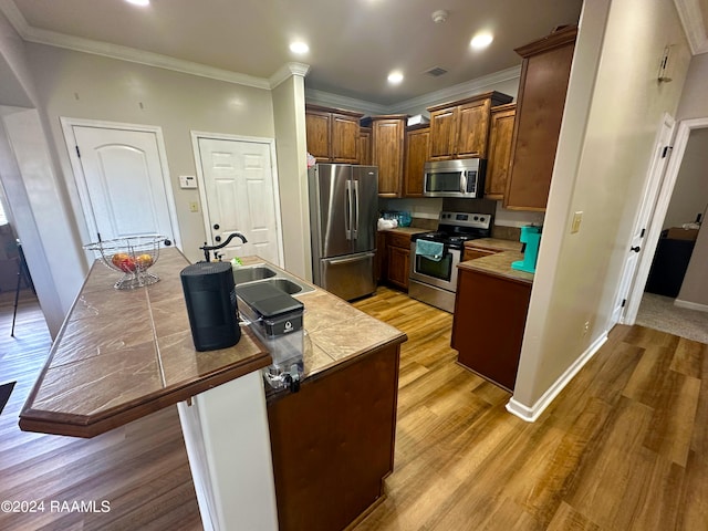 kitchen featuring light hardwood / wood-style flooring, stainless steel appliances, crown molding, and sink