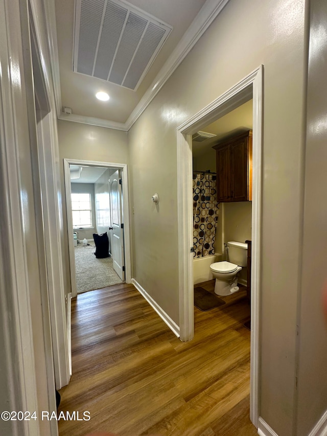 hallway with crown molding and hardwood / wood-style floors