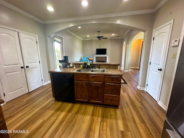 kitchen with ornamental molding, sink, a kitchen island with sink, light hardwood / wood-style flooring, and black dishwasher