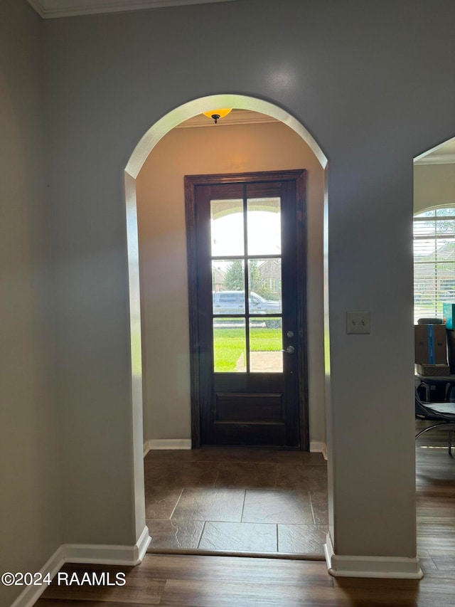 entryway featuring wood-type flooring, a healthy amount of sunlight, and crown molding