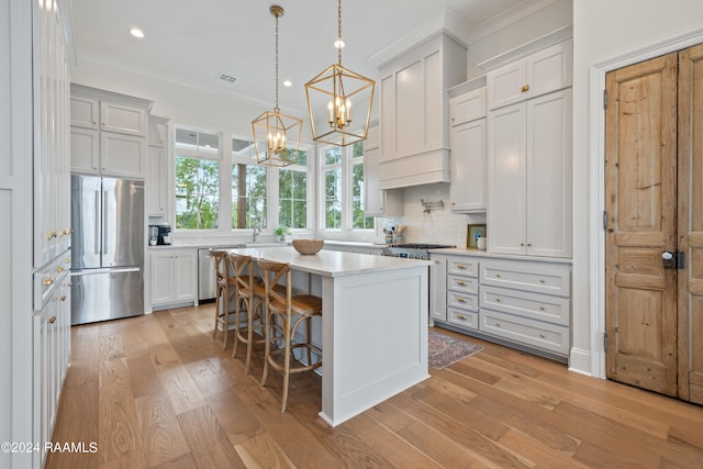 kitchen featuring white cabinets, a breakfast bar area, stainless steel appliances, and a center island