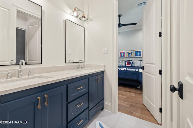 bathroom with wood-type flooring, vanity, ornamental molding, and ceiling fan