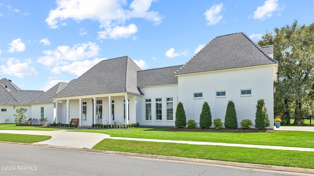 french country inspired facade with a front lawn