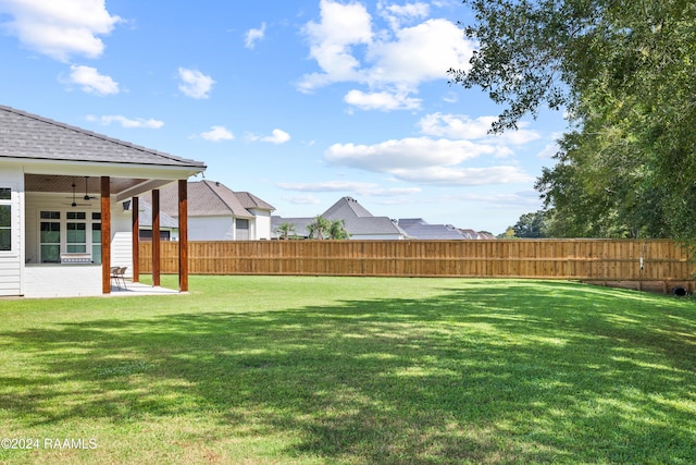 view of yard with ceiling fan and a patio