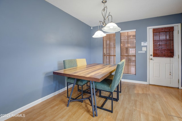 dining room with light wood-type flooring and an inviting chandelier