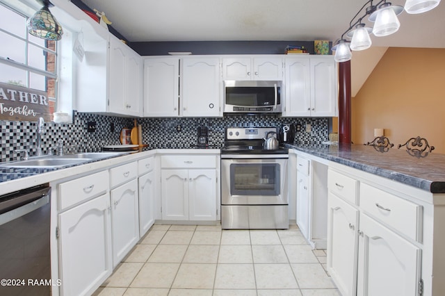 kitchen featuring pendant lighting, white cabinets, decorative backsplash, and appliances with stainless steel finishes