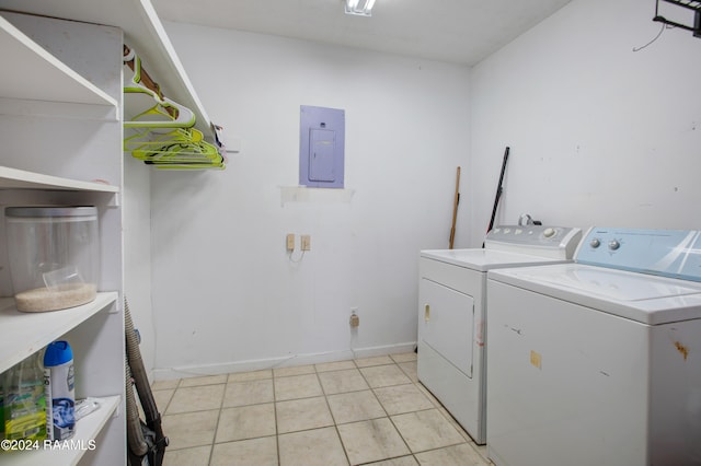 laundry area featuring washing machine and clothes dryer, electric panel, and light tile patterned floors