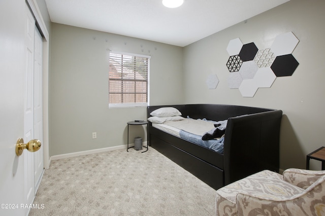 bedroom with light colored carpet and a closet