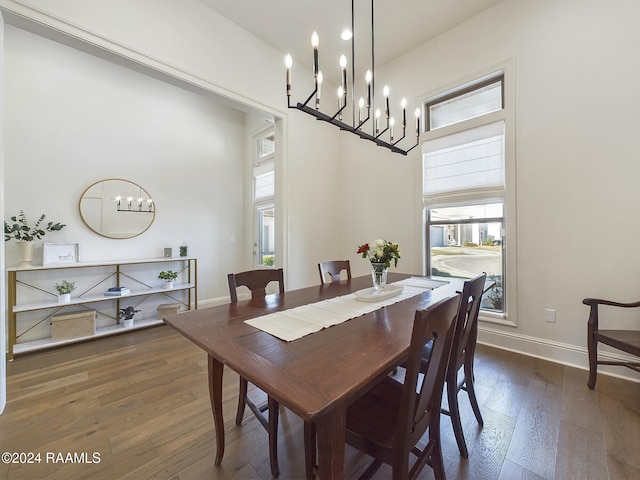 dining space with a chandelier, dark wood-type flooring, and a high ceiling