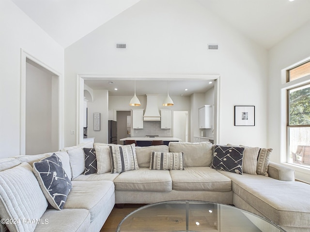 living room with high vaulted ceiling and wood-type flooring