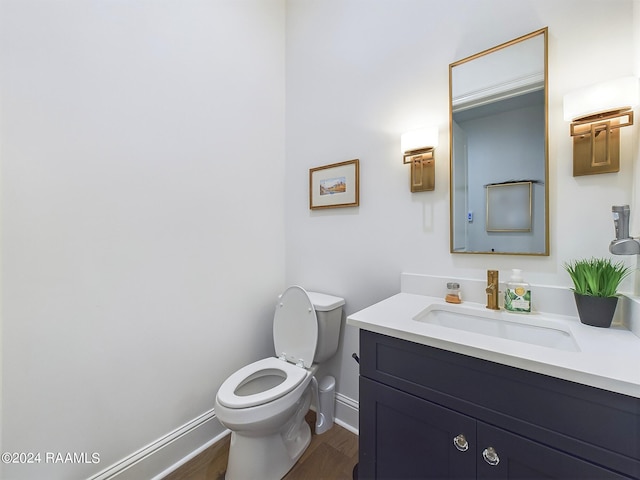 bathroom with vanity, wood-type flooring, and toilet