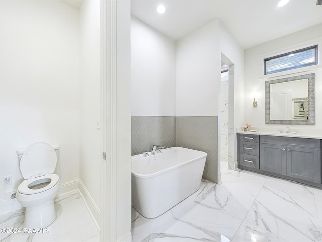 bathroom with toilet, a tub, and vanity