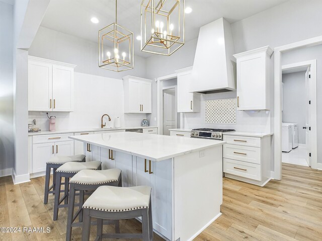 kitchen featuring light wood-type flooring, custom exhaust hood, and white cabinets