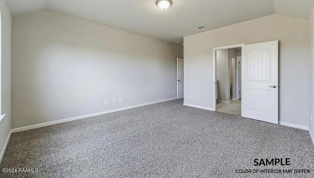 unfurnished bedroom with carpet and vaulted ceiling