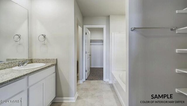 bathroom with tile patterned flooring, vanity, and a tub