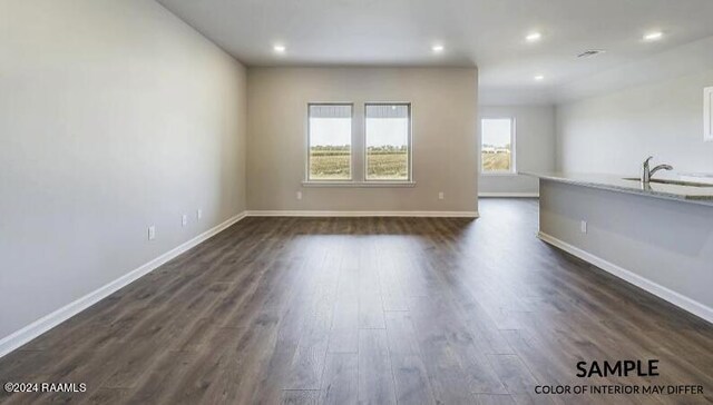 unfurnished living room with dark wood-type flooring and sink