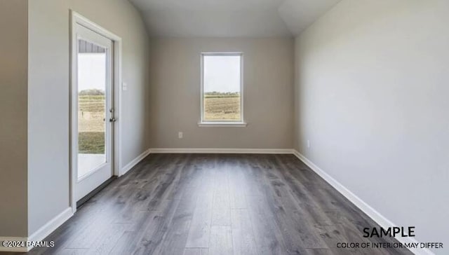 spare room with dark hardwood / wood-style floors and vaulted ceiling