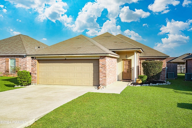 view of front of home featuring a garage, a front lawn, and central AC