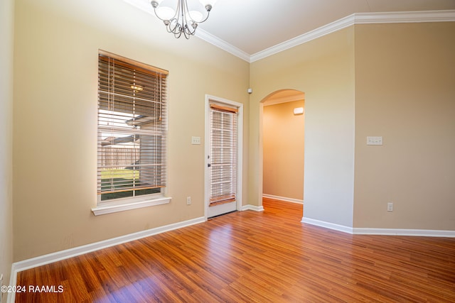 unfurnished room featuring wood-type flooring, a notable chandelier, and ornamental molding