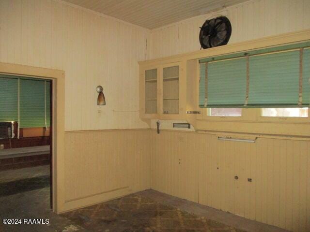 414 E Main St, Ville Platte, LA 70586 - kitchen featuring wood walls, a wainscoted wall, and glass insert cabinets