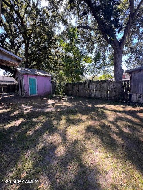 414 E Main St, Ville Platte, LA 70586 - view of yard with a storage shed, a fenced backyard, and an outdoor structure