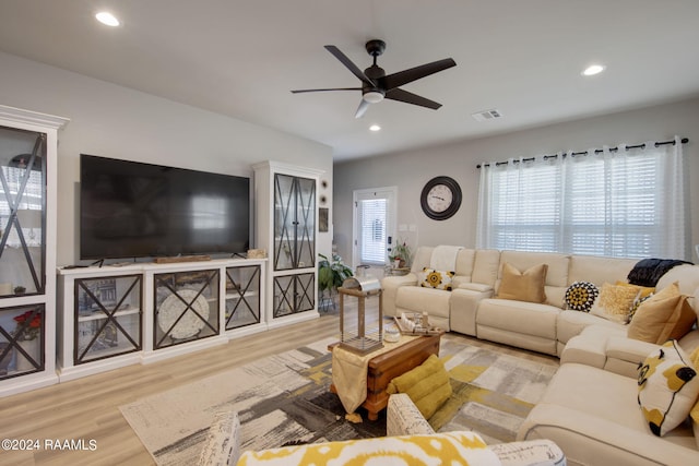 living room featuring light wood-type flooring and ceiling fan