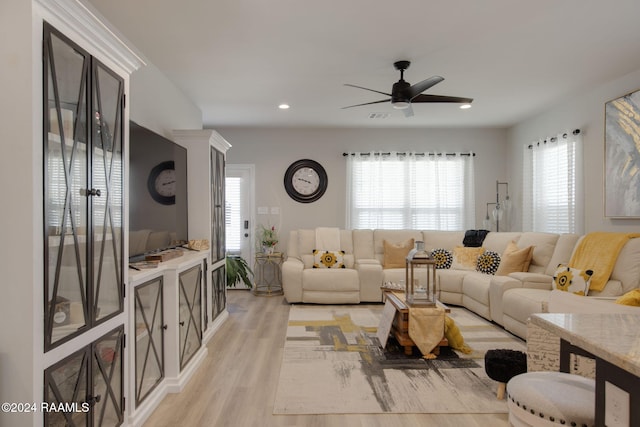 living room with light hardwood / wood-style flooring and ceiling fan