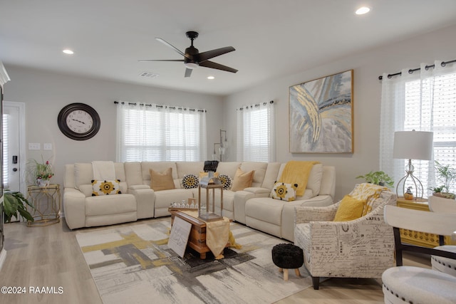 living room featuring ceiling fan, light hardwood / wood-style floors, and a healthy amount of sunlight