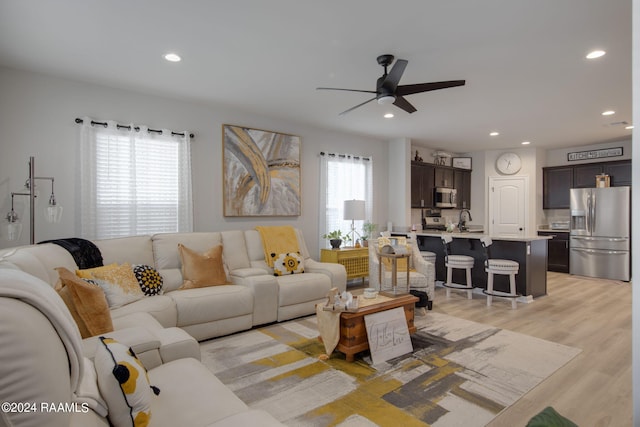 living room with ceiling fan, light hardwood / wood-style flooring, sink, and a wealth of natural light