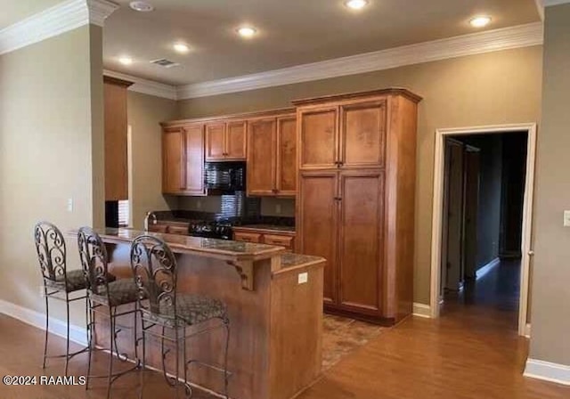 147 Oakbend Dr, Lafayette, LA 70506 - kitchen featuring brown cabinets, baseboards, black microwave, and a breakfast bar area