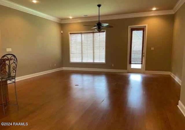 empty room featuring ceiling fan, dark wood-type flooring, and crown molding