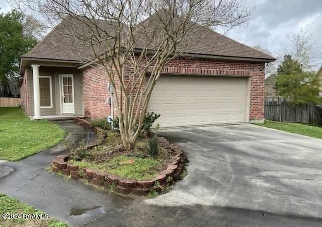 147 Oakbend Dr, Lafayette, LA 70506 - ranch-style house featuring driveway, a garage, brick siding, fence, and a shingled roof
