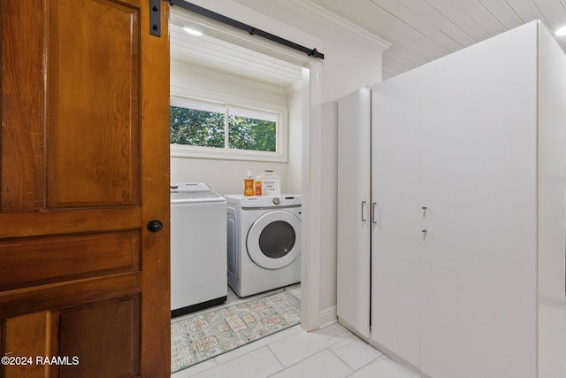 washroom with washer and clothes dryer, a barn door, light tile patterned floors, and crown molding