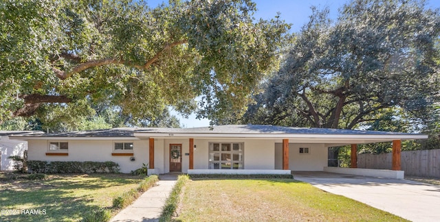 ranch-style home featuring a front yard, a porch, and a carport